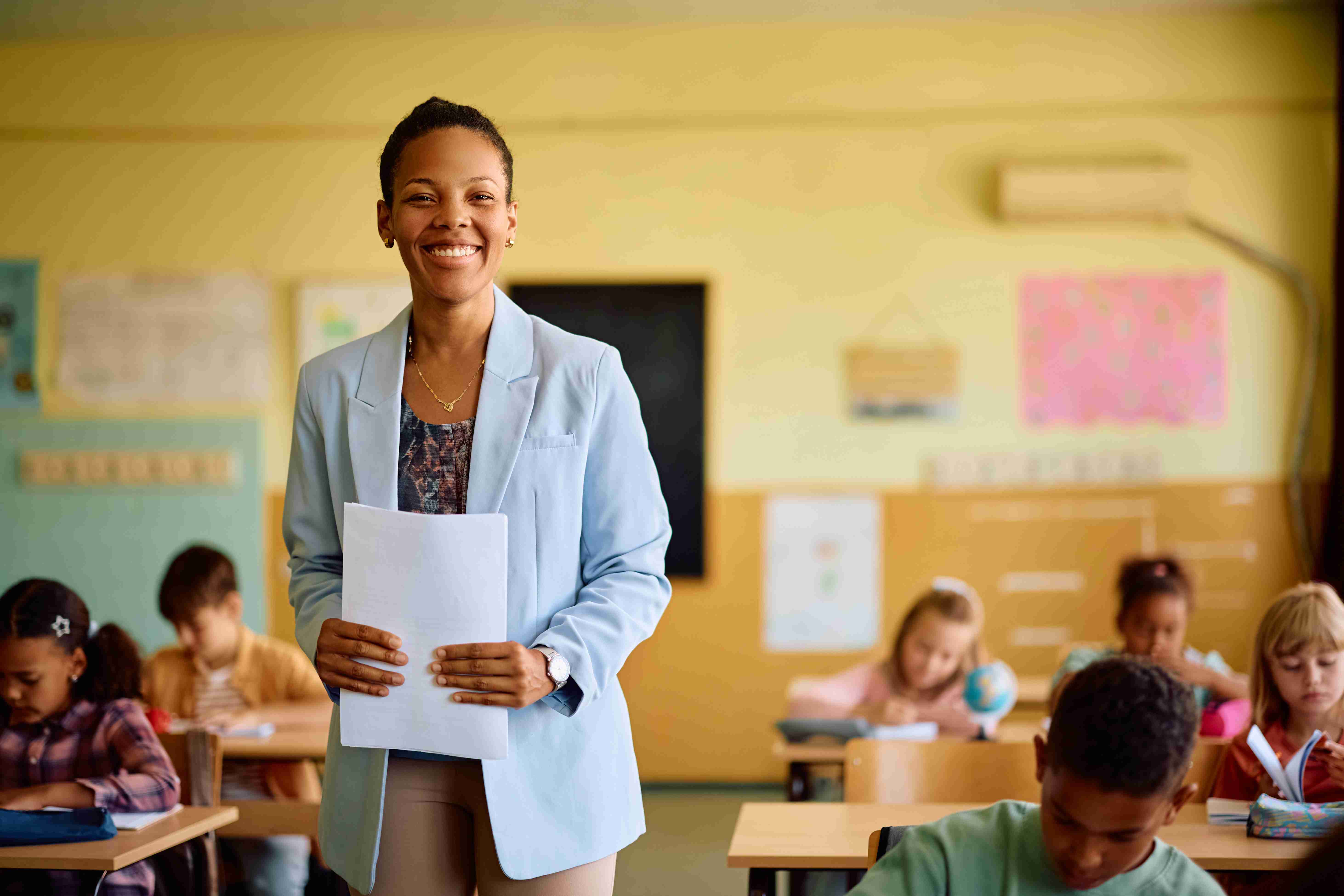 Happy black elementary school teacher among her st